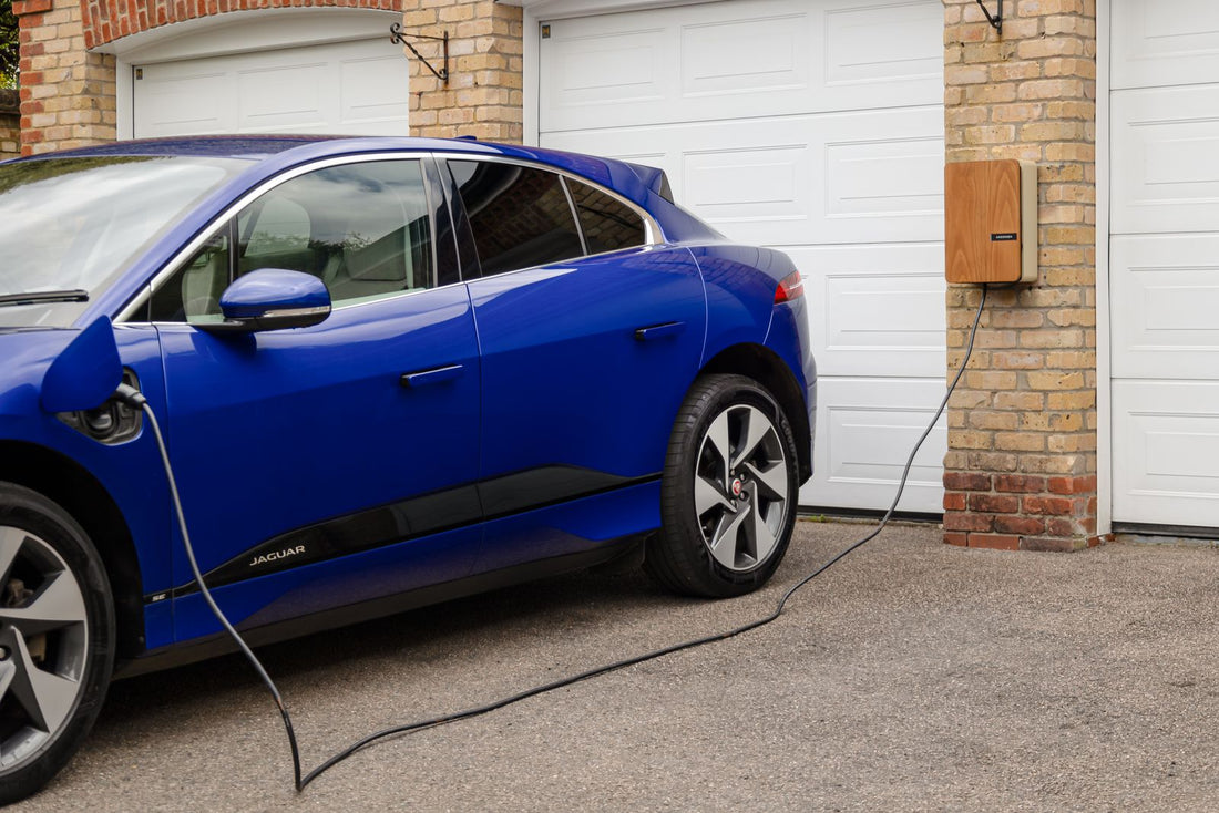 Voiture électrique en recharge à la maison sur un chargeur mural dans un garage