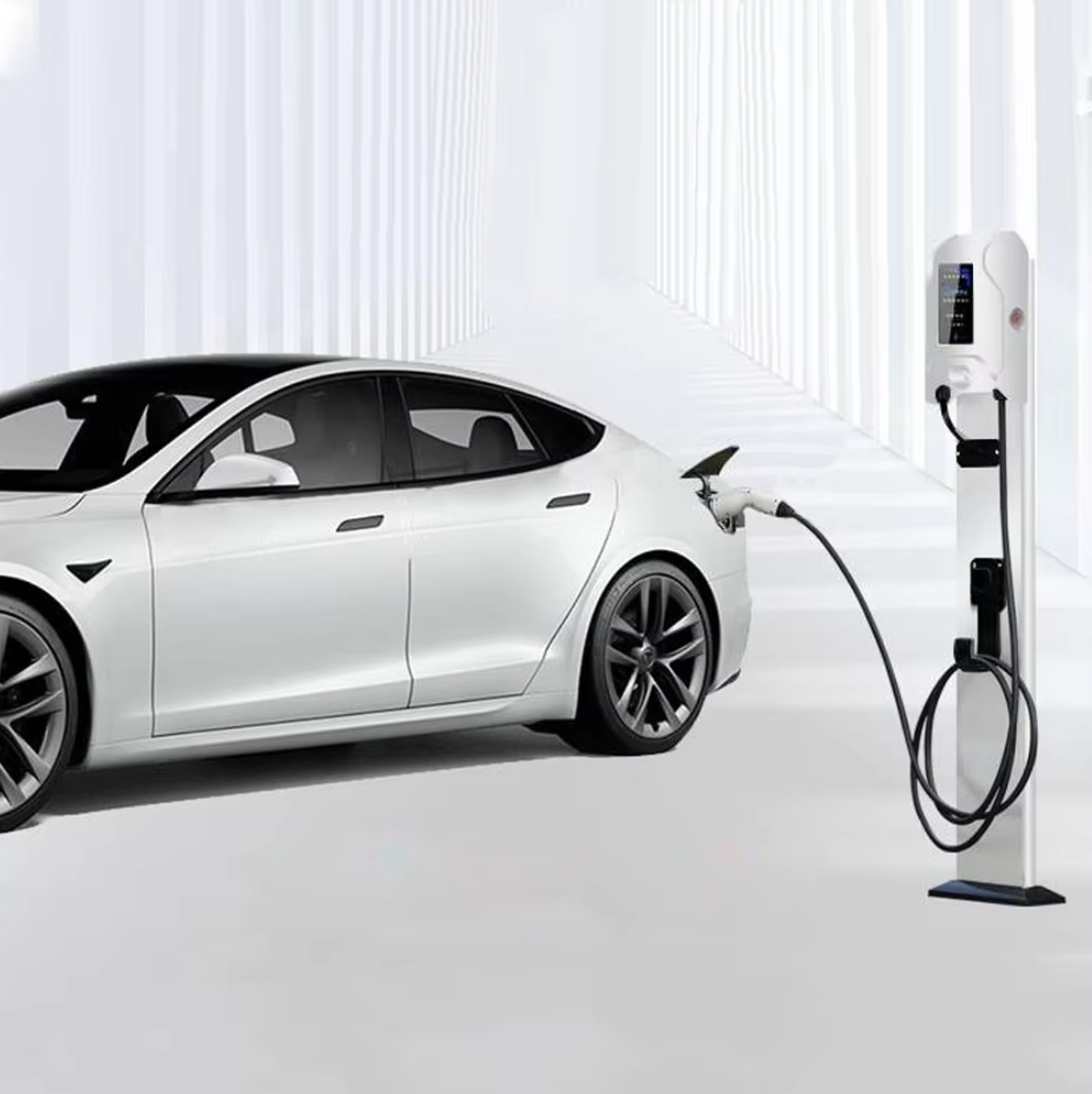 Une voiture électrique Tesla blanche, connectée à une borne de recharge. Le câble de recharge est branché à l'arrière du véhicule, soulignant la modernité et l'élégance du design