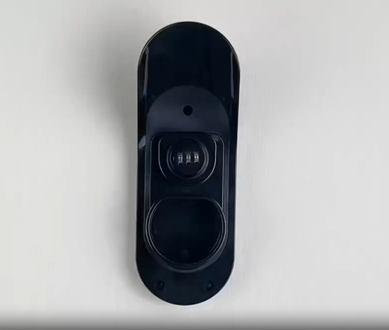 Cadenas noir à combinaison à trois chiffres, fixé sur un support mural en plastique noir.